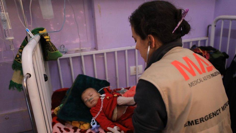 A baby is treated by a MAP medic at al-Aqsa hospital