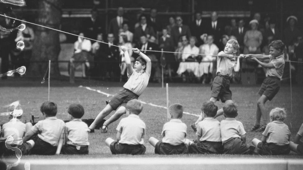 The young Prince Charles takes part in the tug o' war at his school sports day.