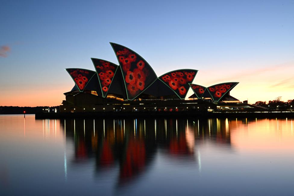 The sails of the Sydney Opera House are illuminated by a projection of poppies during a Remembrance Day Dawn Service in Sydney on November 11, 2022.