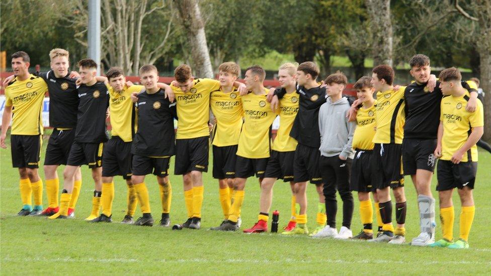 Players link arms to watch the penalties being taken