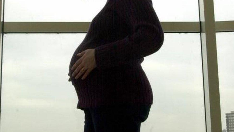 pregnant woman in front of window