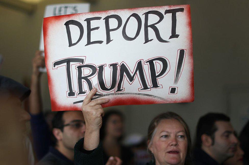 A Deport Trump sign