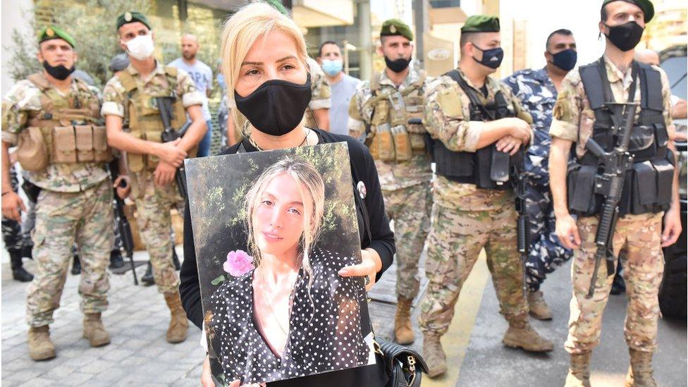 Woman holds picture of person killed in Beirut port explosion (file photo)