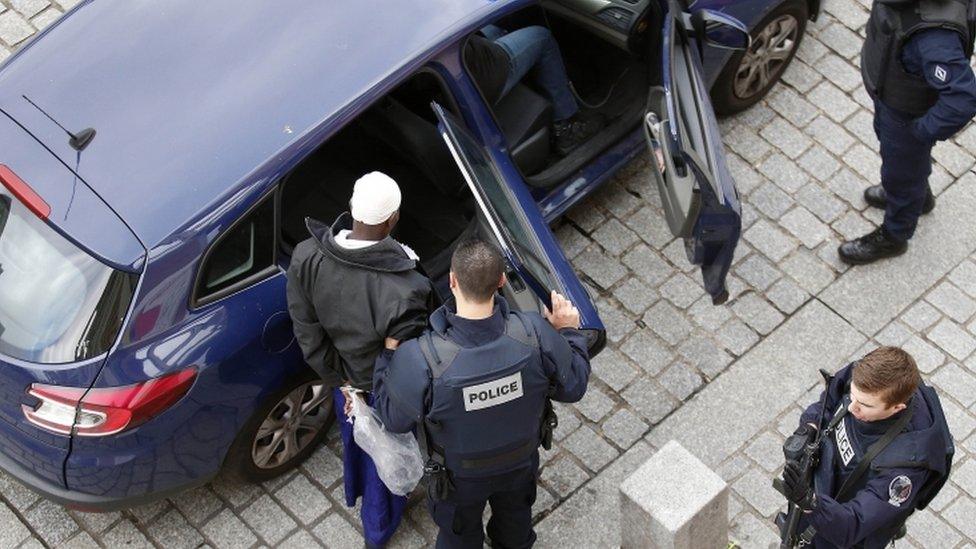 A man is arrested during an anti-terror operation in Saint-Denis, Paris