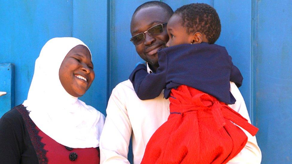 Family photo by the gate to the compound