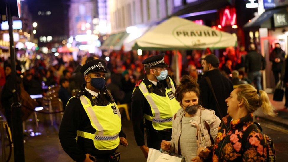 Police officers wearing protective face masks are