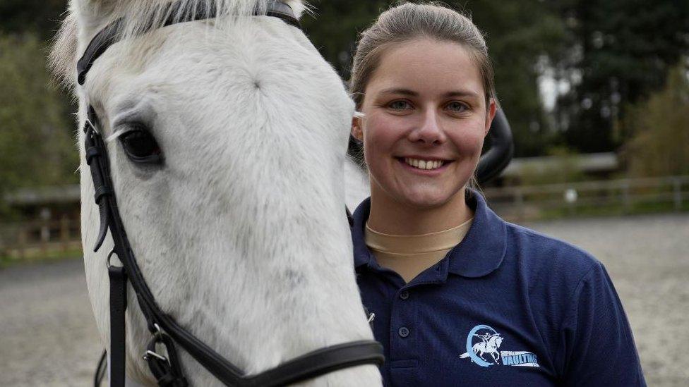 Coach Annika Sievert posing next to a white horse