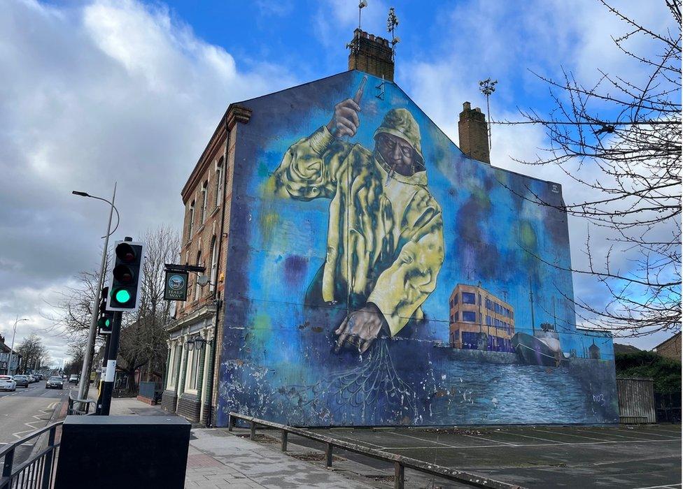 A mural depicting a fisherman at work painted onto the side of a house in Hessle Road, Hull