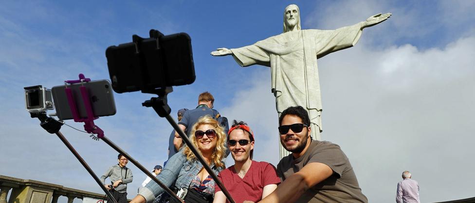 Tourists pose for selfies in front of Christ the Redeemer - 30 July 2016