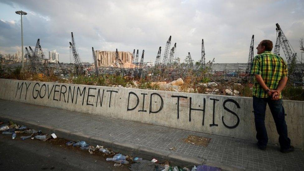 File photo showing a man looks at the remains of Beirut's port following a huge explosion (11 August 2020)