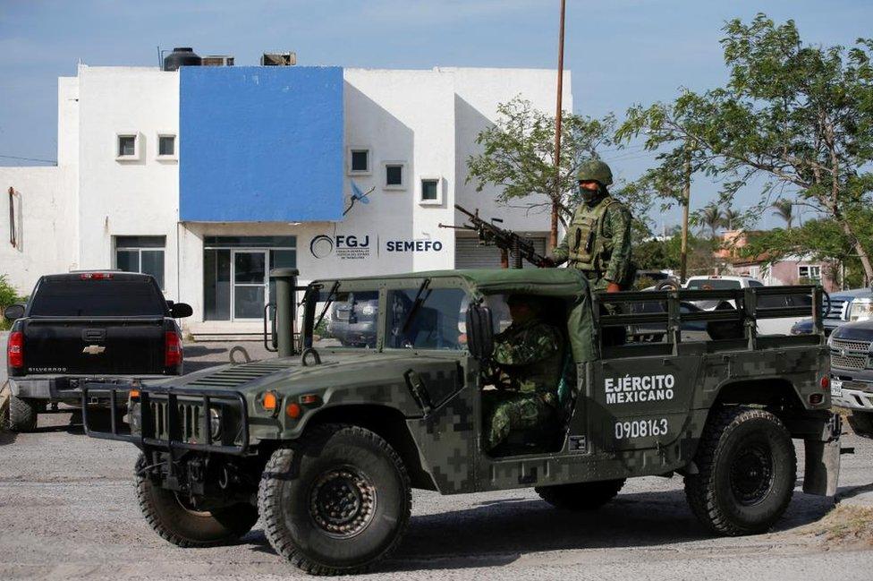 Troops stand guard at the morgue where the Americans' bodies were taken