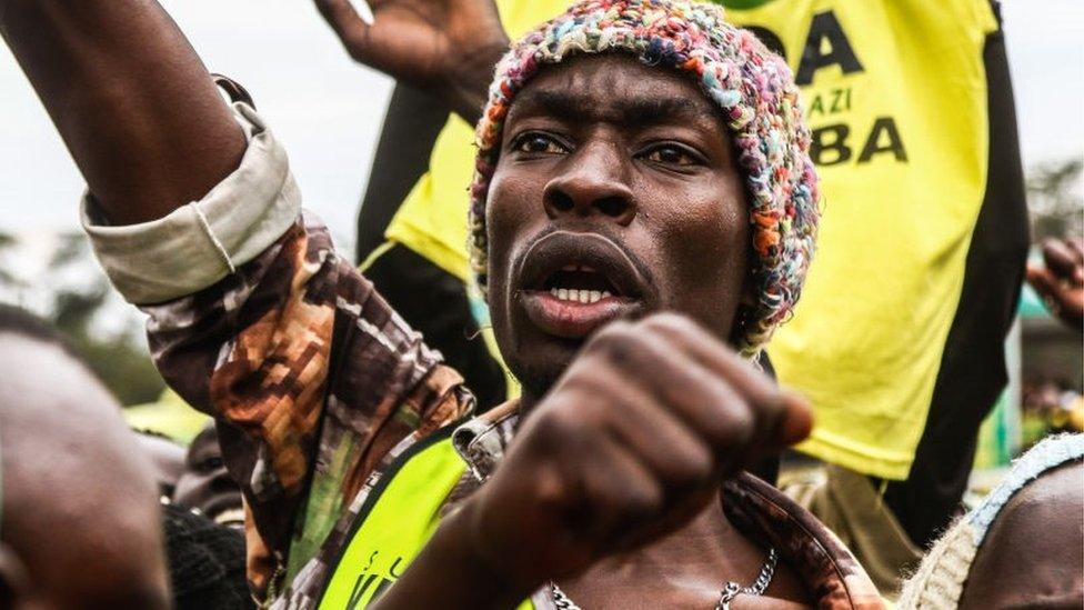 A Kenya Kwanza Political Alliance supporter cheers during a campaign rally in Salgaa Trading Centre ahead of the general elections