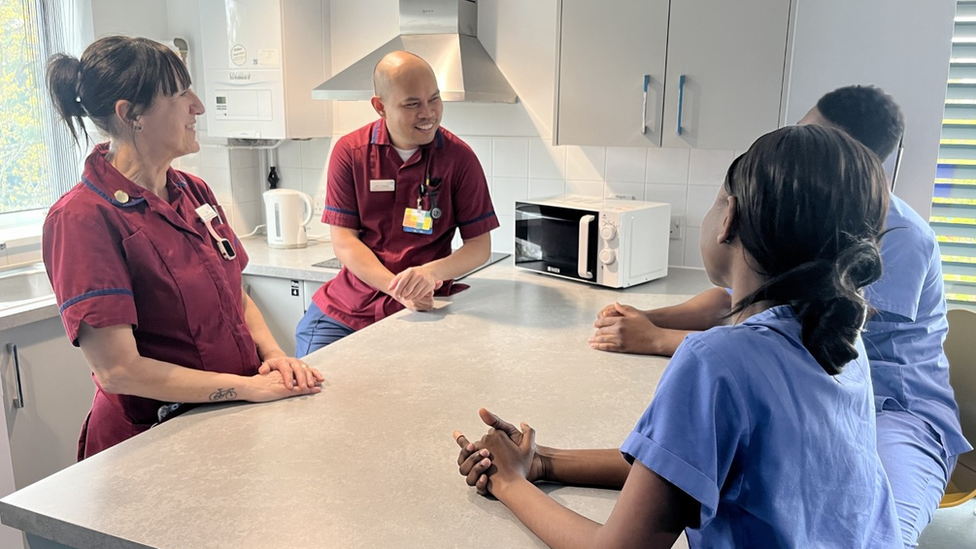 Group of 4 healthcare workers in a hospital kitchen