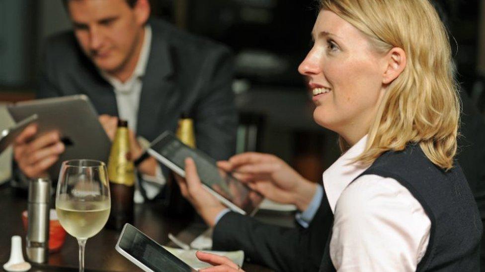 Diners using iPads at a restaurant