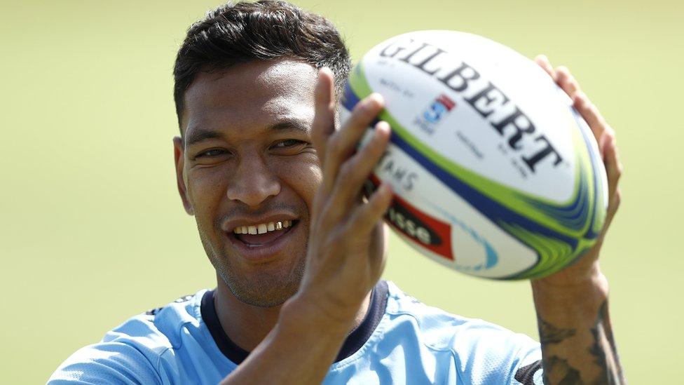 Israel Folau smiles as he catches a rugby ball