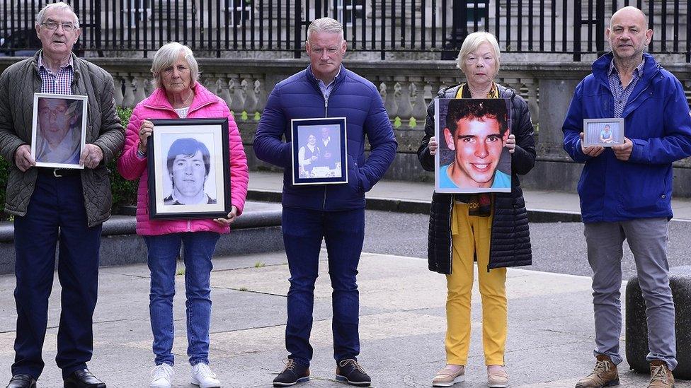 Relatives of the Sean Anderson, Thomas Armstrong, Dwayne O'Donnell, Thomas Casey and Phelim McNally hold photographs of them outside a court in Belfast after the announcement of the new inquests