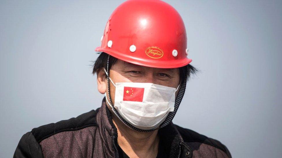 A captain wears a mask in a ship at Yangluo container port in Wuhan, Hubei Province, China.