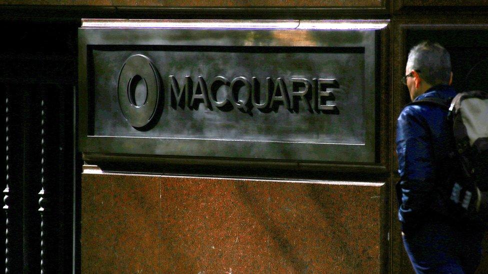 A pedestrian walks past the logo of Australia's biggest investment bank Macquarie Group Ltd on the outside of their Sydney office headquarters in central Sydney, Australia, July 18, 2017.