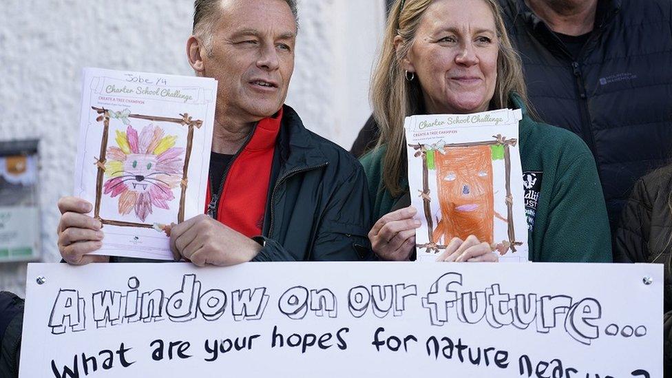 Chris Packham holding up artwork at protest