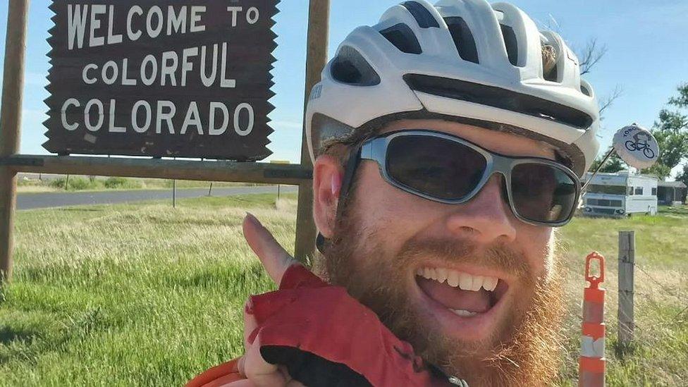 Anthony Butcher next to a Colorado sign