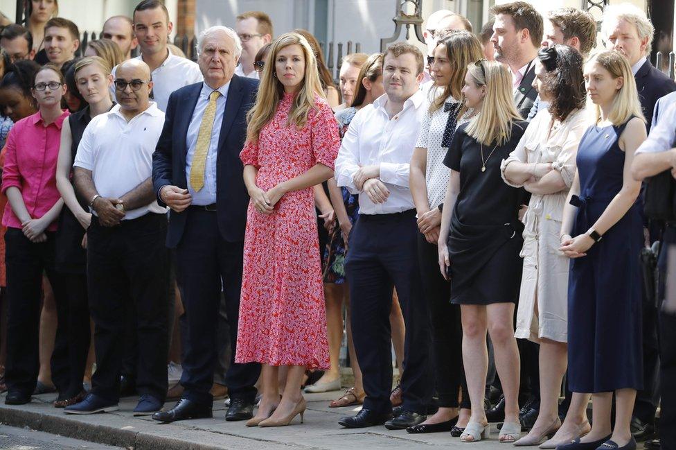 Carrie Symonds (C), girlfriend of Britain's new Prime Minister Boris Johnson, waits for the prime minister's arrival with members of staff in Downing Street in London on 24 July 2019