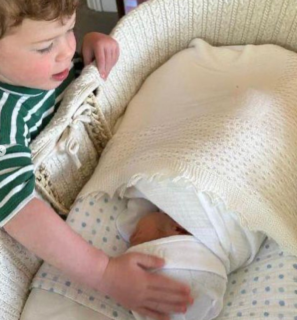 August Brooksbank rests his hand on Ernest his new brother's head