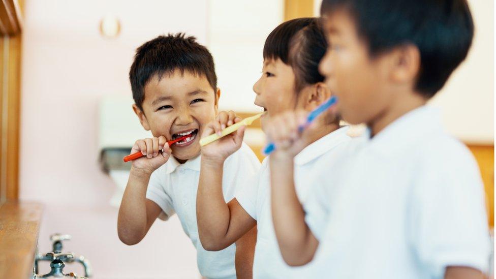 children brushing teeth together