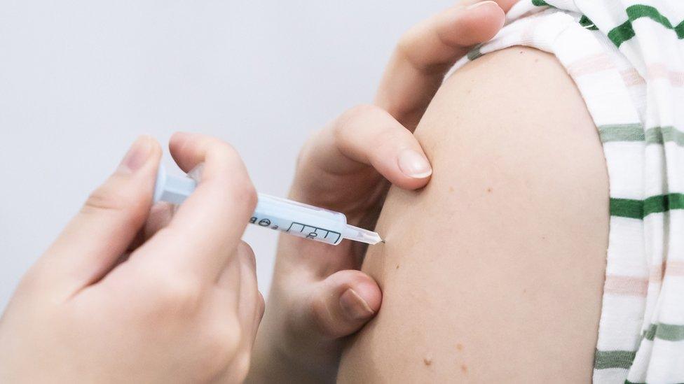 A person being injected with a Codvid-19 vaccination booster