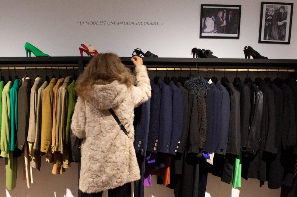 Racks of suit jackets arranged by shade