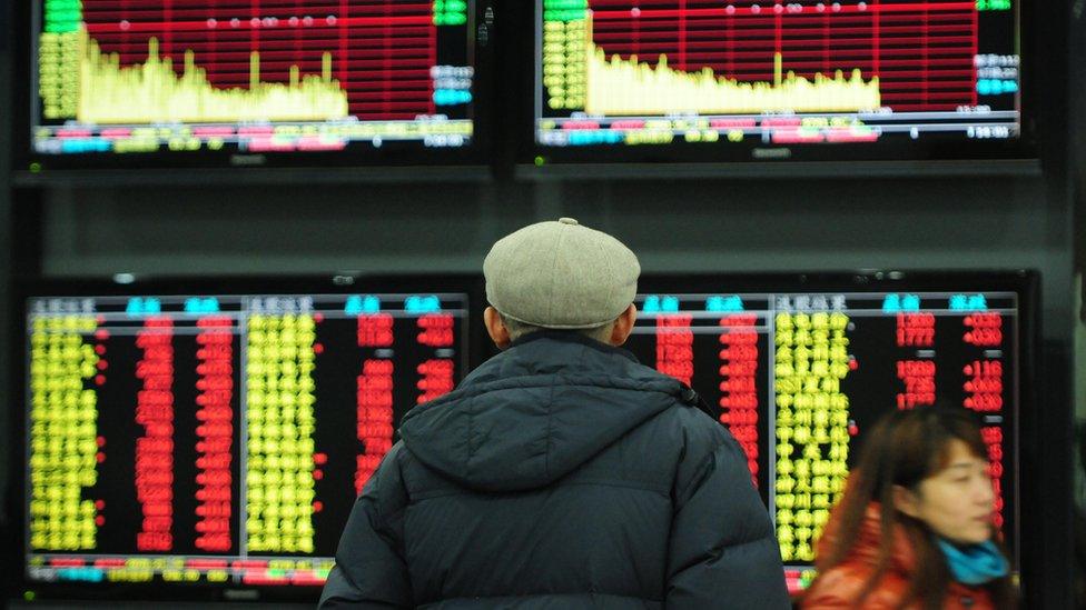 Investor observes stock market screens at an exchange hall on December 17, 2015