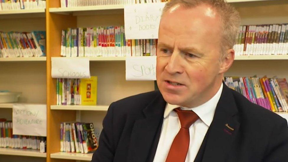 A man sitting in a school library.