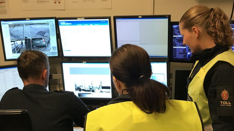 Officers monitor cars at an unmanned border crossing