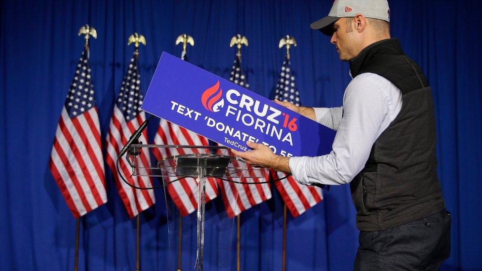 A worker for Republican presidential candidate Sen. Ted Cruz, R-Texas, removes the campaign sign from the podium following primary night campaign event in Indianapolis, Tuesday, May 3, 2016