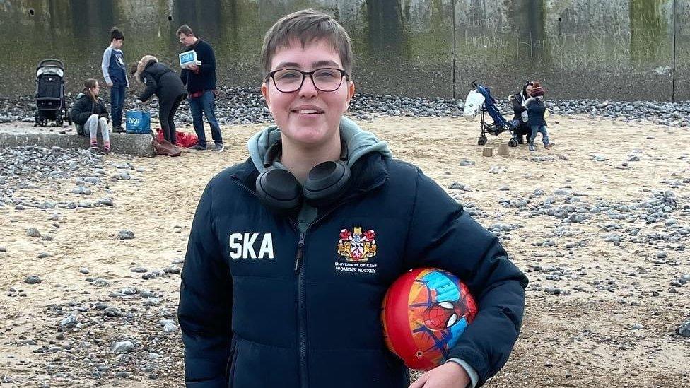 Saffron on a beach holding a football