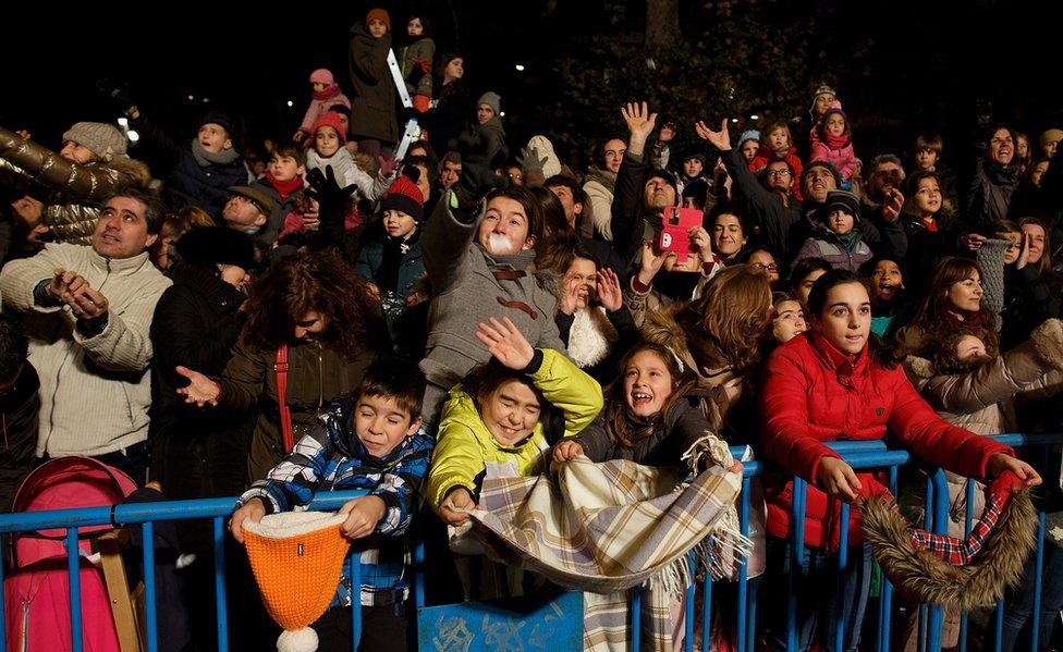 Children react as performers (not pictured) throw sweets to them during the 'Cabalgata de Reyes,' or Three Kings parade, on January 5, 2016