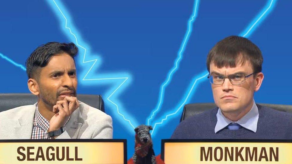 Man with short hair and beard and man with short dark hair and glasses on the University Challenge set