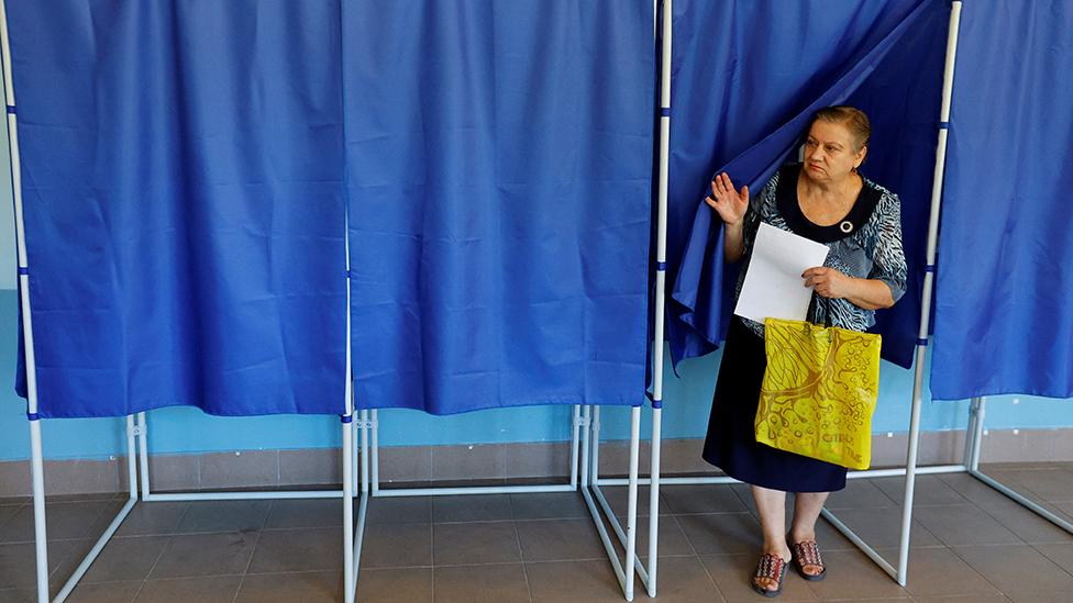 A woman walks out of a voting booth at a polling station during local elections held by the Russian-installed authorities in the course of Russia-Ukraine conflict in Donetsk, Russian-controlled Ukraine, September 8, 2023