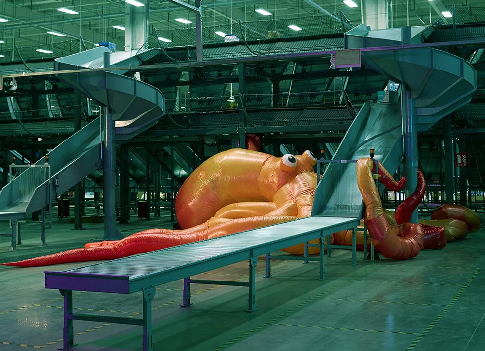 A photo by Cao Fei showing an inflatable octopus next to an industrial shoot in a warehouse