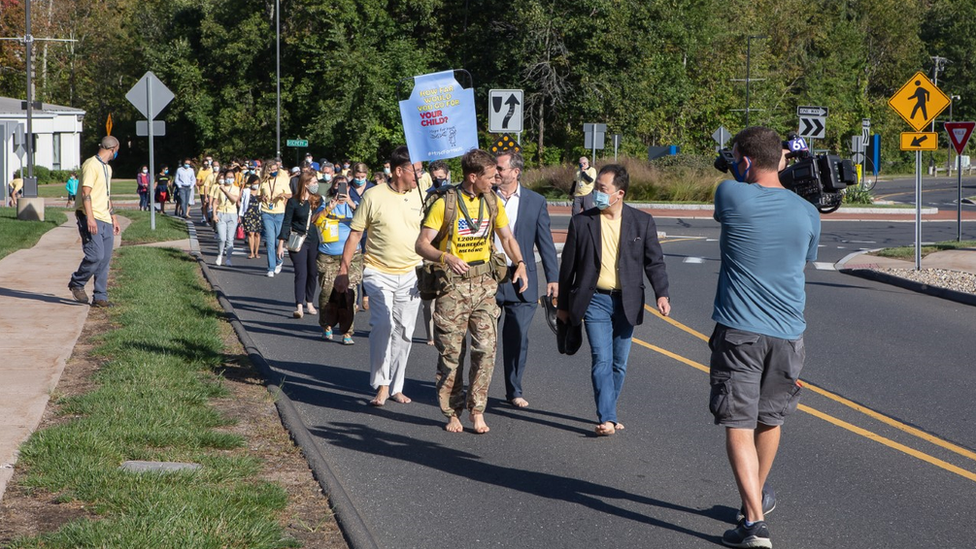 Chris accompanied by a number of walkers on his barefoot challenge.