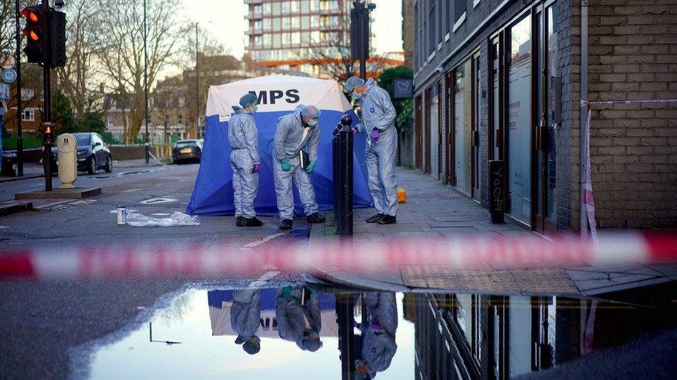 Forensic officers work near to the scene where a 17-year-old boy died