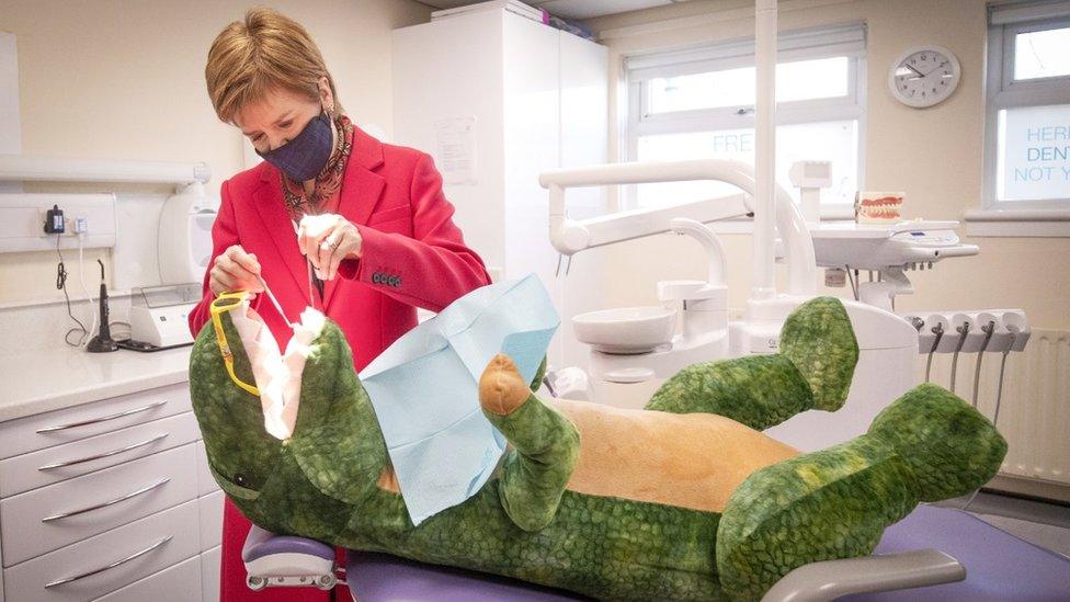 Scotland's First Minister Nicola Sturgeon, leader of the Scottish National Party (SNP), checks the teeth of "Dentosaurus" during a visit to the Thornliebank Dental Care centre in Glasgow during the election campaign. Scotland holds its next parliamentary election on May 6. Picture date: Friday April 16, 2021.