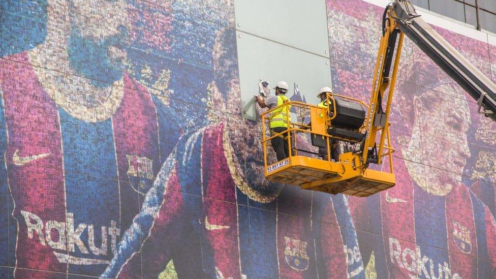 Pictures of Lionel Messi are being taken down at the Nou Camp stadium in Barcelona.