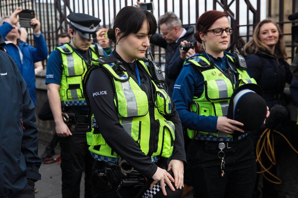 British Transport Police officers pause after laying floral tributes on Westminster Bridge