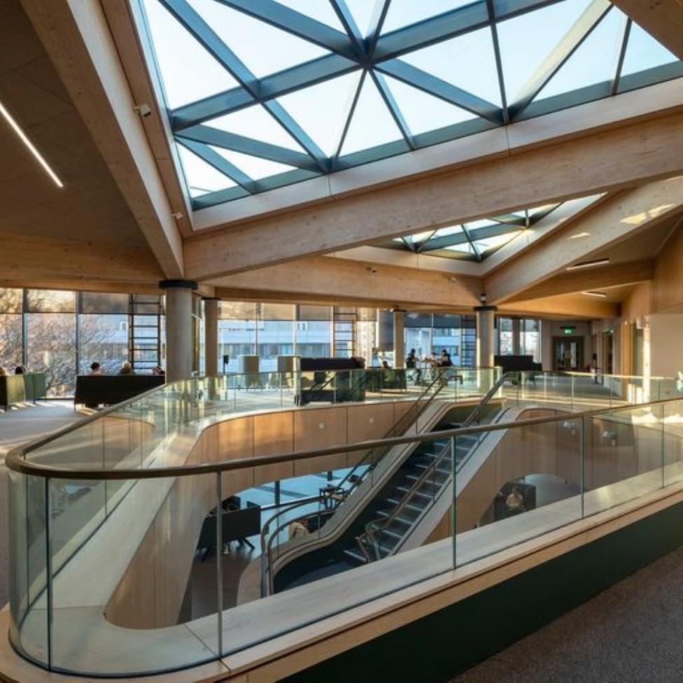 The new central atrium of the Campus Central building is open and airy with wide walkways and high windows,