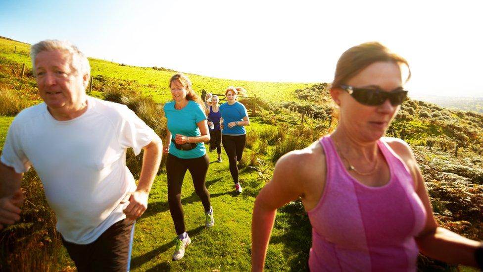 Men and women running a mountain trail