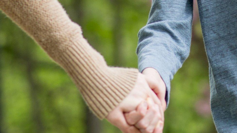 Mother holding child's hand