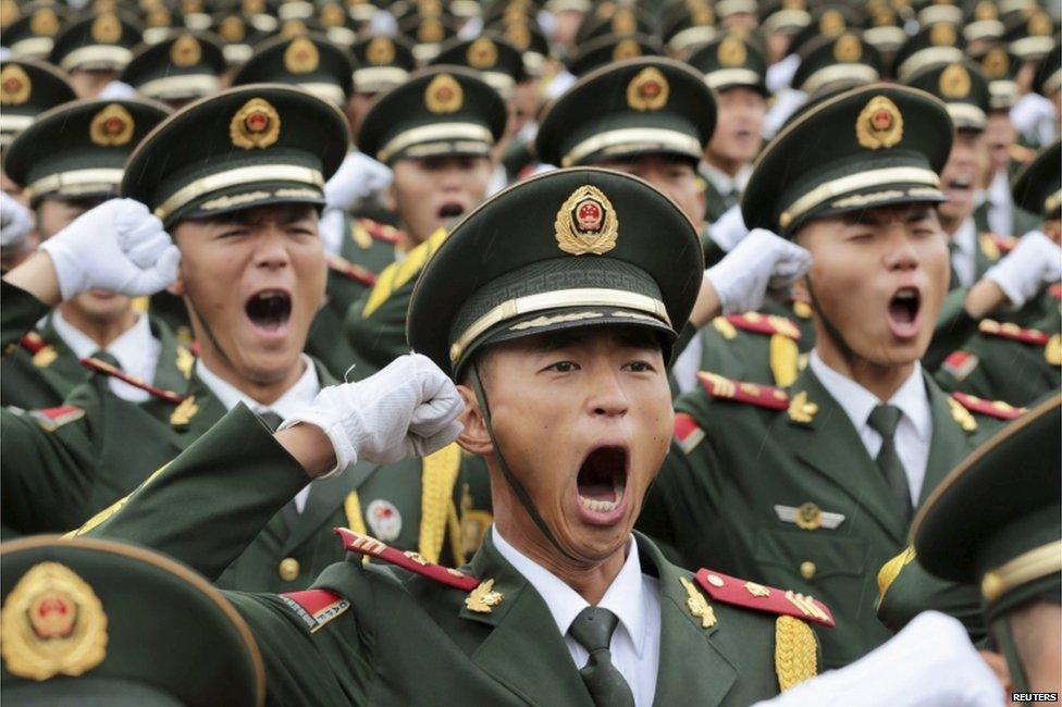 Paramilitary policemen and members of a gun salute team shout slogans at an oath-taking ceremony for the upcoming military parade to mark the 70th anniversary of the end of the World War Two, at a military base in Beijing, China, 1 September 2015