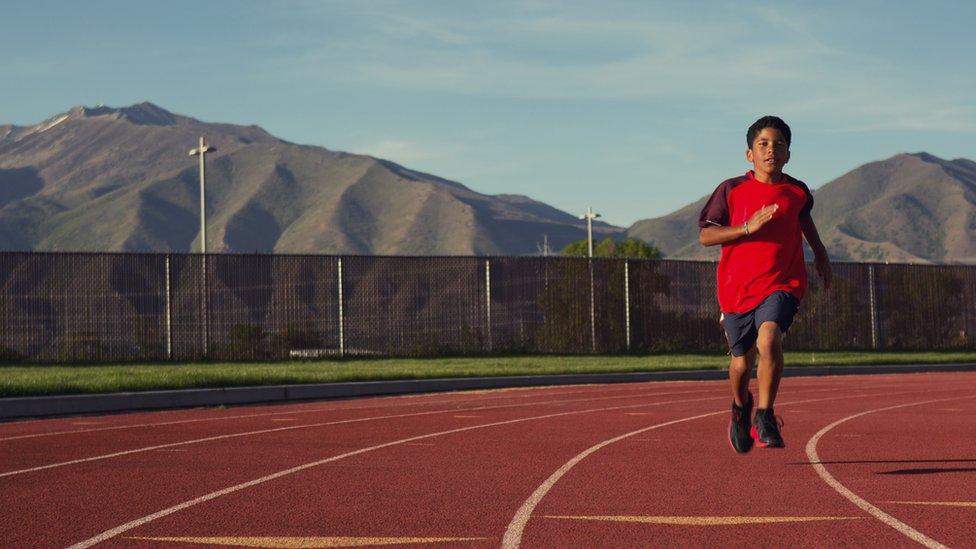 A child runs on a track