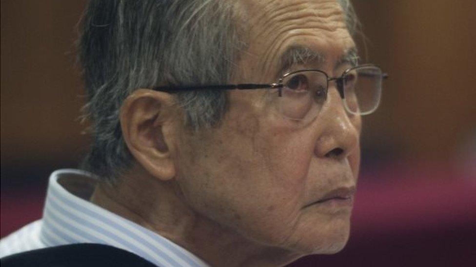 Peru's jailed, former President Alberto Fujimori, photographed through a glass window, attends his trial at a police base on the outskirts of Lima, Peru, Tuesday, June 28, 2016.