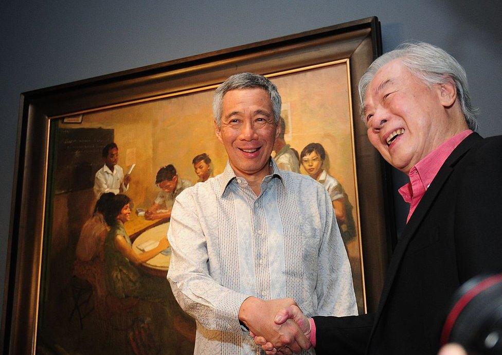 Singapore Prime Minister Lee Hsien Loong (L) shakes hands with artist Chua Mia Tee during the opening of the newly restored National Gallery, formerly the City Hall and High Court building, in Singapore on 23 November 2015.